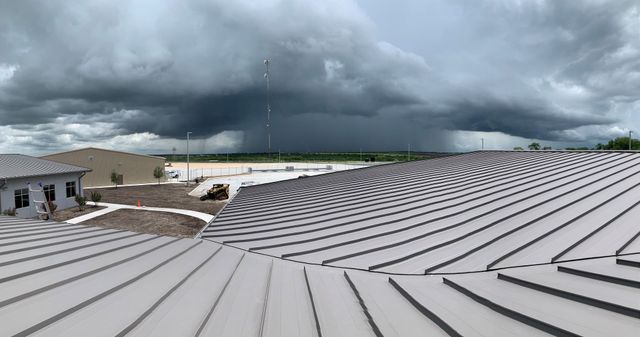 A storm front rolling in over a large commercial metal roof in Texas