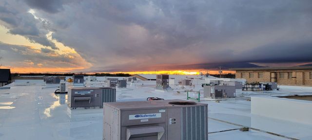Sunset over a commercial rooftop with HVAC units in the foreground